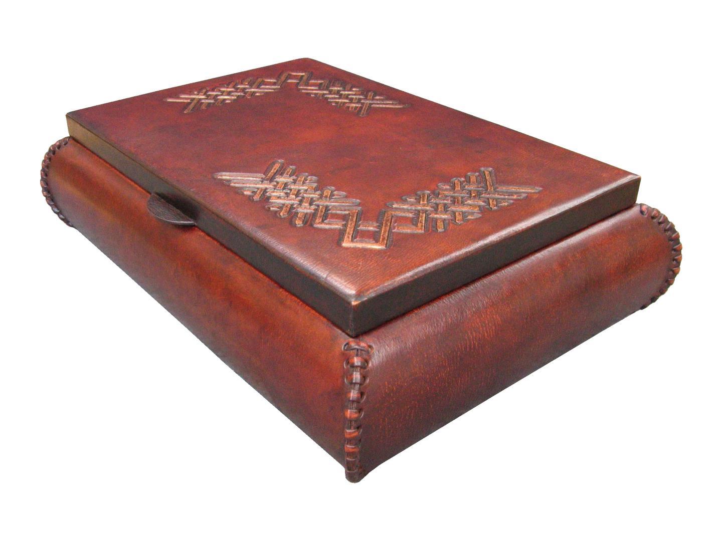 leather box with tooling/carved gold design on the top and hand stitches on side of the piece